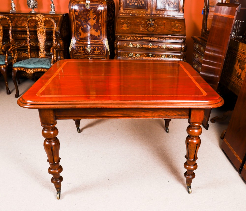 A 19th-century William IV flame mahogany extending dining table set on turned legs with brass castors. View X