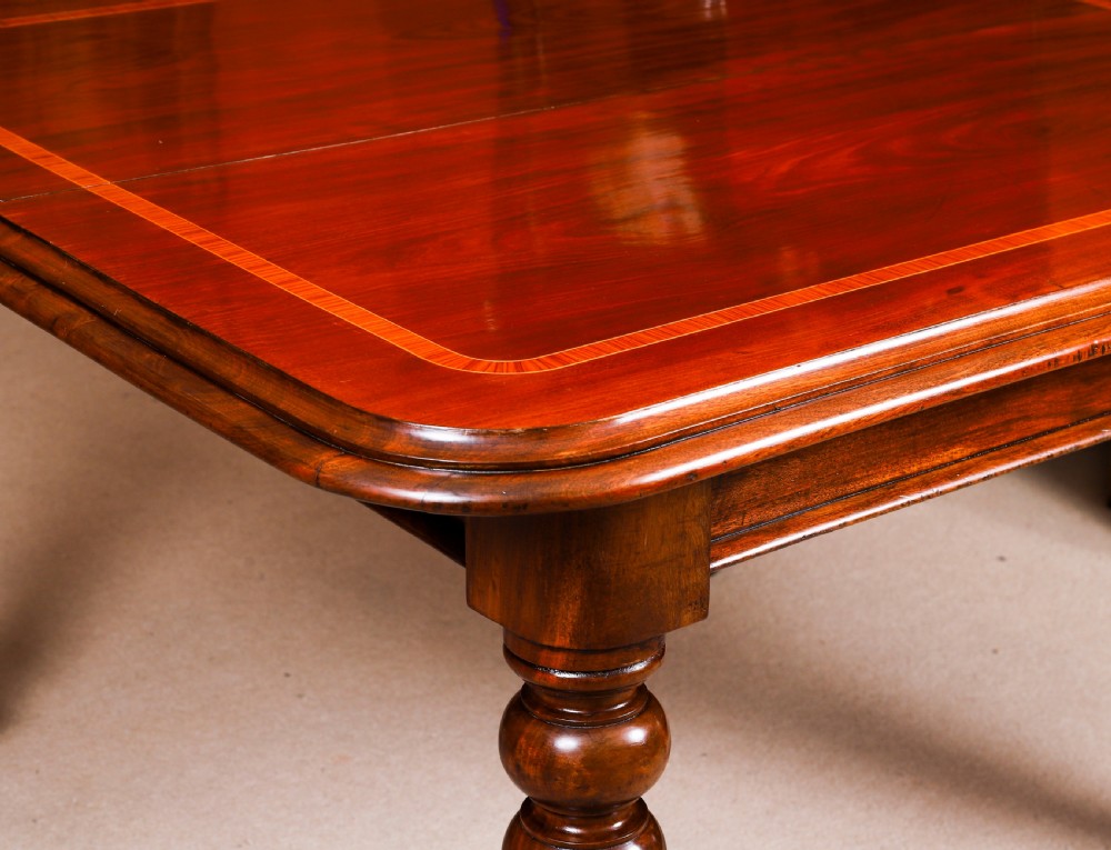 A 19th-century William IV flame mahogany extending dining table set on turned legs with brass castors. View XIII