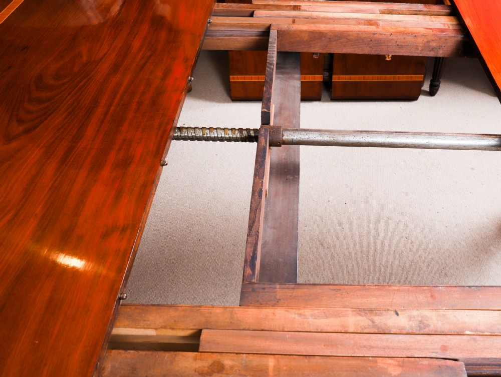 A 19th-century William IV flame mahogany extending dining table set on turned legs with brass castors. View XIV