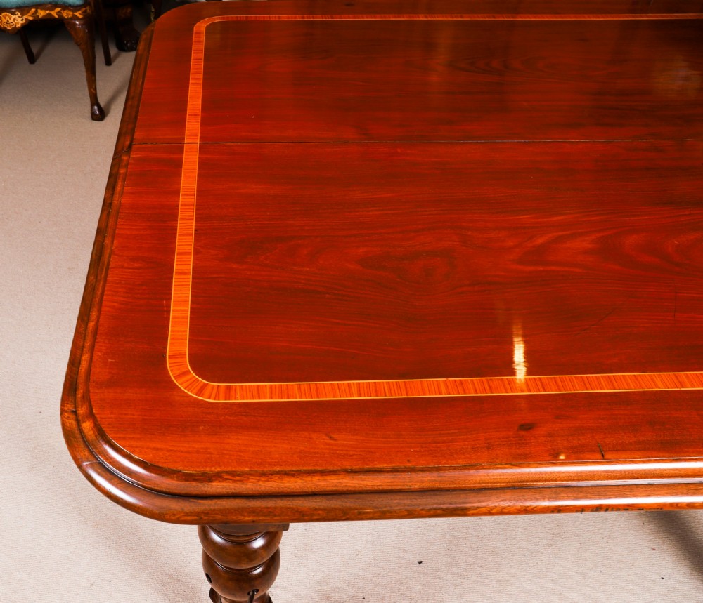 A 19th-century William IV flame mahogany extending dining table set on turned legs with brass castors. View XVII