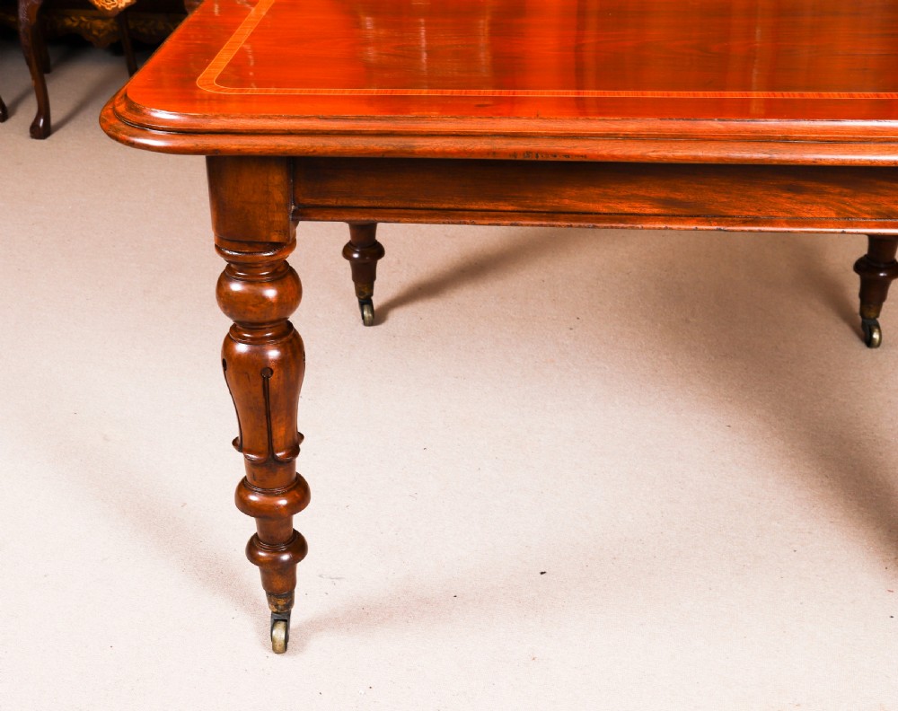 A 19th-century William IV flame mahogany extending dining table set on turned legs with brass castors. View XVIII