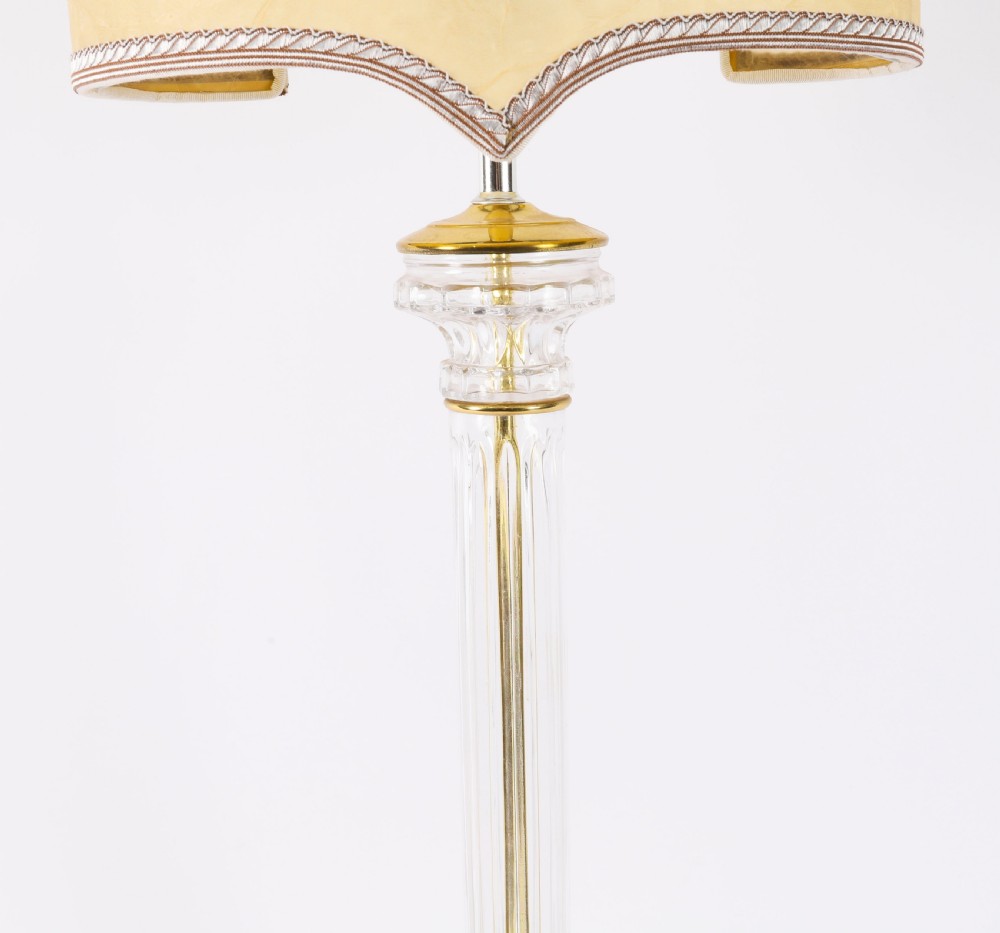 A pair of Art Deco table lamps featuring fluted clear glass column stems on square gilded metal bases with arched cream lampshades. View V