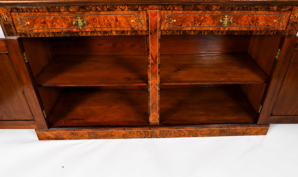 A 19th-century Victorian burr walnut bookcase featuring upper glazed doors, intricate inlay detailing, two drawers, and lower cupboard doors. View XV