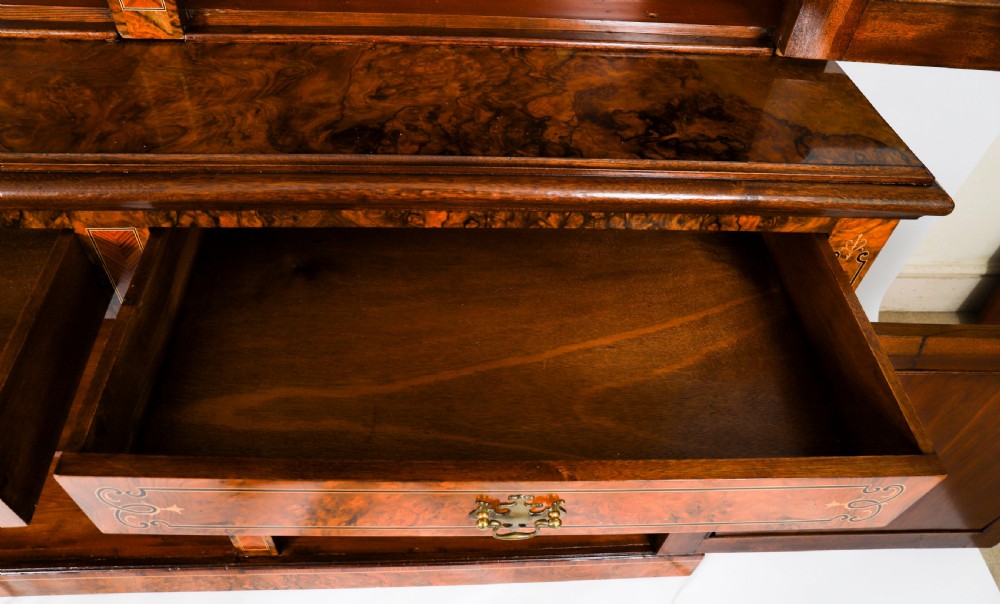 A 19th-century Victorian burr walnut bookcase featuring upper glazed doors, intricate inlay detailing, two drawers, and lower cupboard doors. View XVIII