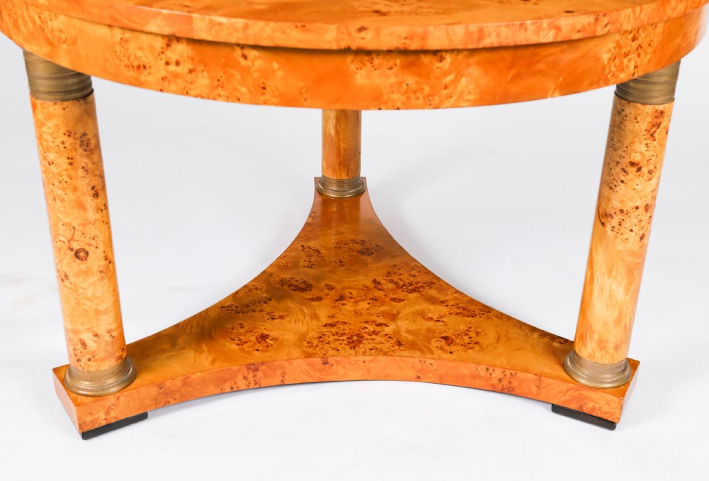 A circular 20th-century Biedermeier revival coffee table made from burr elm with three column legs set on a triform plinth base. View VII