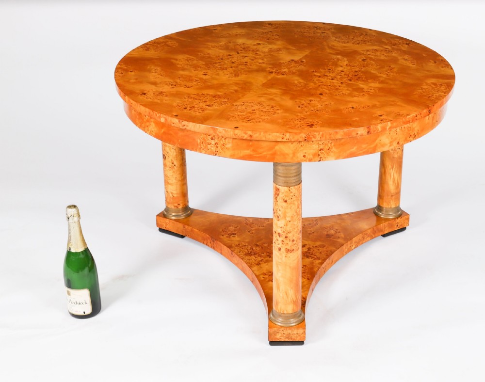 A circular 20th-century Biedermeier revival coffee table made from burr elm with three column legs set on a triform plinth base. View XI