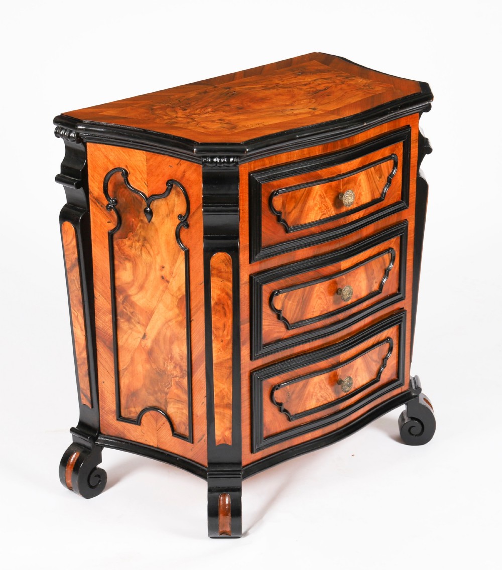 A pair of 18th-century Italian burr walnut serpentine bedside chests featuring ebonised mouldings, three drawers, and scroll feet. View IV