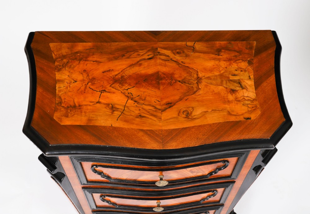 A pair of 18th-century Italian burr walnut serpentine bedside chests featuring ebonised mouldings, three drawers, and scroll feet. View VIII