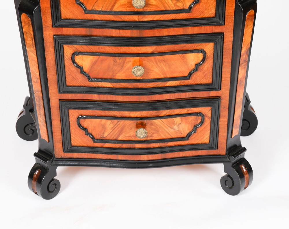 A pair of 18th-century Italian burr walnut serpentine bedside chests featuring ebonised mouldings, three drawers, and scroll feet. View IX