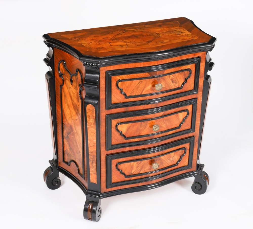 A pair of 18th-century Italian burr walnut serpentine bedside chests featuring ebonised mouldings, three drawers, and scroll feet. View XVII