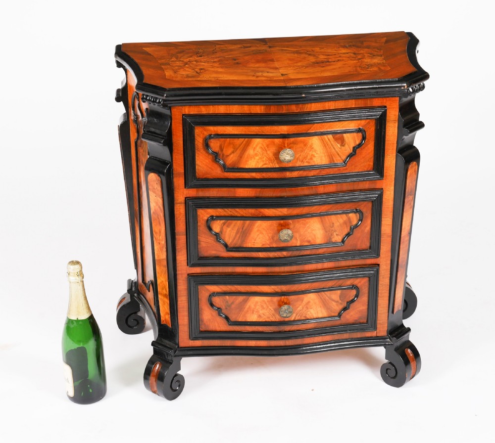 A pair of 18th-century Italian burr walnut serpentine bedside chests featuring ebonised mouldings, three drawers, and scroll feet. View XIX