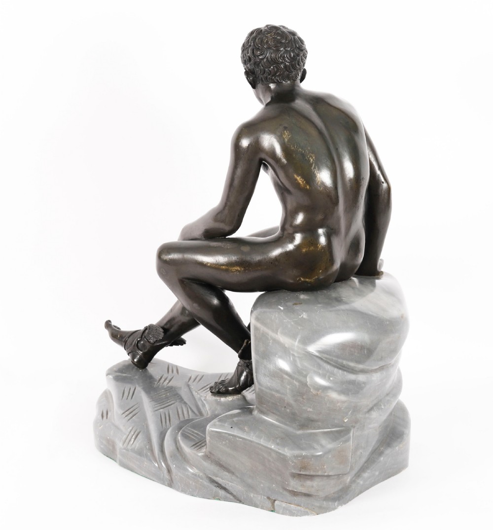 A dark patinated bronze sculpture depicting a nude seated Hermes resting on a carved grey marble base. View VII