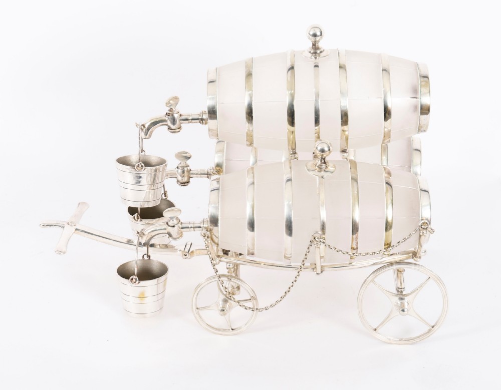 A 19th-century silver-plated carriage frame holding three frosted crystal barrels with taps and hanging miniature bucket tot cups. View II