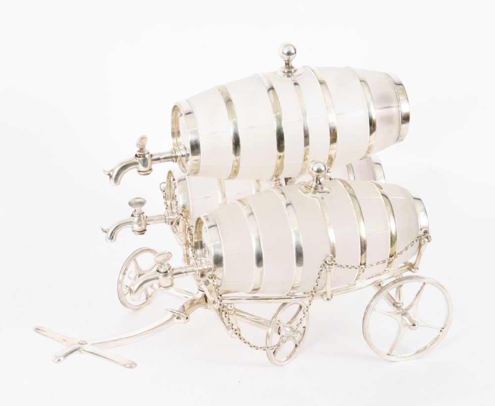 A 19th-century silver-plated carriage frame holding three frosted crystal barrels with taps and hanging miniature bucket tot cups. View V