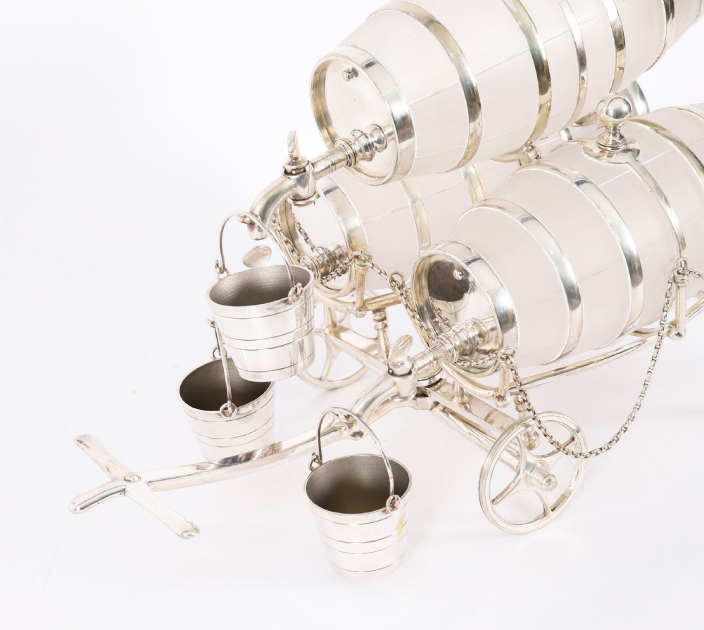A 19th-century silver-plated carriage frame holding three frosted crystal barrels with taps and hanging miniature bucket tot cups. View XII
