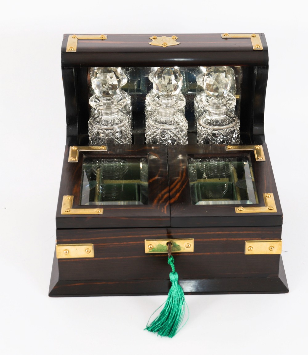 A nineteenth-century coromandel wood scent bottle casket with brass mounts opening to reveal cut-glass bottles and mirrored compartments. View II