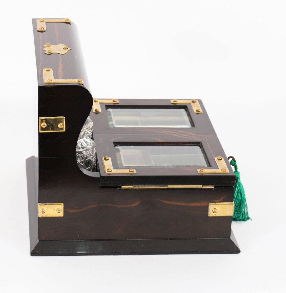 A nineteenth-century coromandel wood scent bottle casket with brass mounts opening to reveal cut-glass bottles and mirrored compartments. View VI