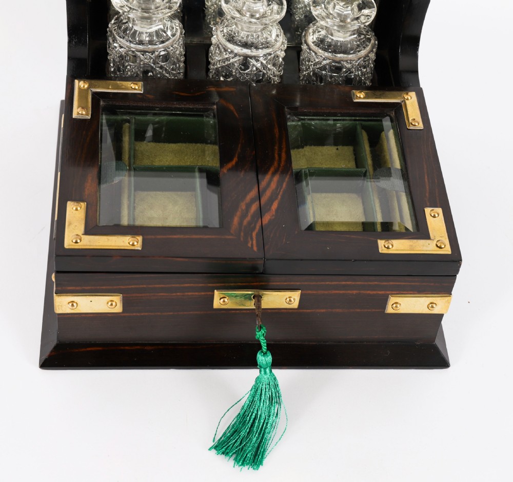 A nineteenth-century coromandel wood scent bottle casket with brass mounts opening to reveal cut-glass bottles and mirrored compartments. View VIII