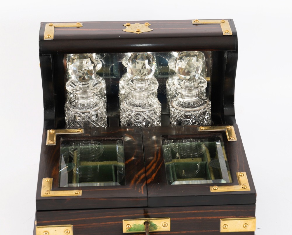 A nineteenth-century coromandel wood scent bottle casket with brass mounts opening to reveal cut-glass bottles and mirrored compartments. View IX