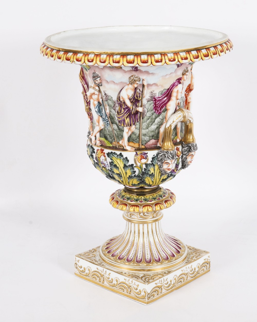 A 19th-century Capodimonte porcelain urn featuring classical figures in high relief, polychrome enamelling, gilded handles, and a square base.