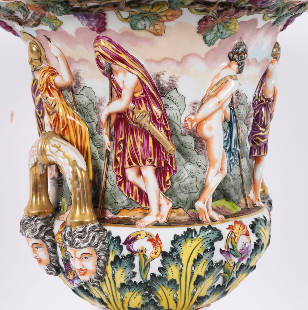 A 19th-century Capodimonte porcelain urn featuring classical figures in high relief, polychrome enamelling, gilded handles, and a square base. View IX