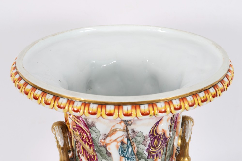 A 19th-century Capodimonte porcelain urn featuring classical figures in high relief, polychrome enamelling, gilded handles, and a square base. View X