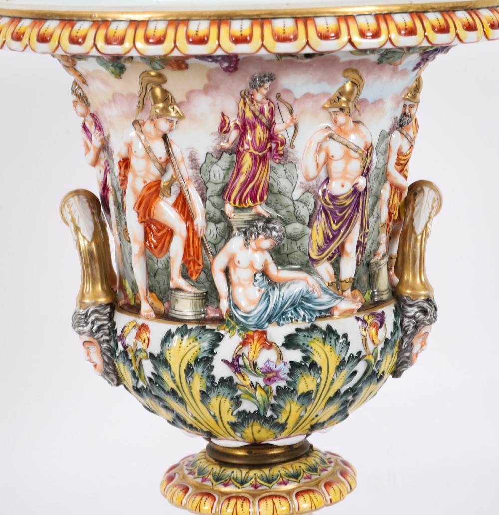 A 19th-century Capodimonte porcelain urn featuring classical figures in high relief, polychrome enamelling, gilded handles, and a square base. View XIV