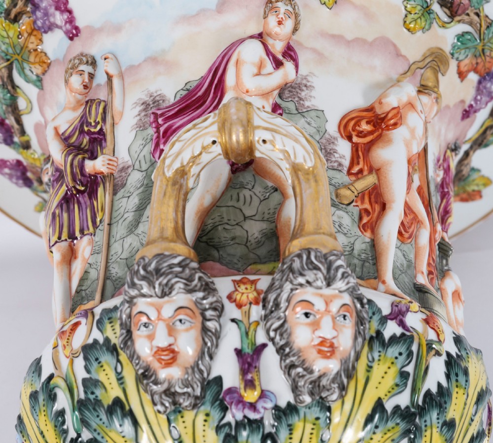 A 19th-century Capodimonte porcelain urn featuring classical figures in high relief, polychrome enamelling, gilded handles, and a square base. View XVI