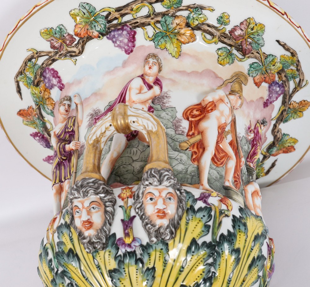A 19th-century Capodimonte porcelain urn featuring classical figures in high relief, polychrome enamelling, gilded handles, and a square base. View XVII