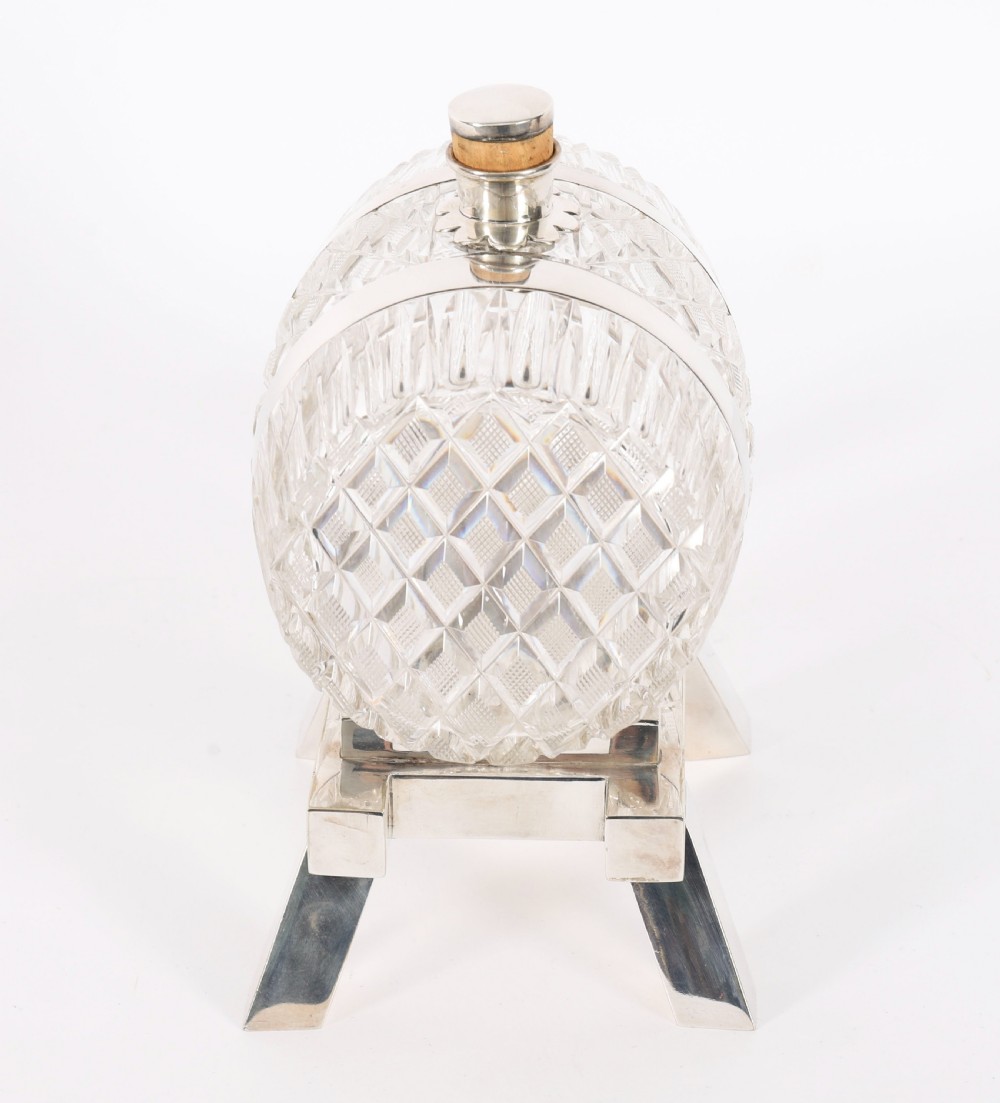 A nineteenth-century cut crystal barrel decanter with silver-plated hoops, tap, and miniature bucket accessory resting on a four-legged silver stand. View XI