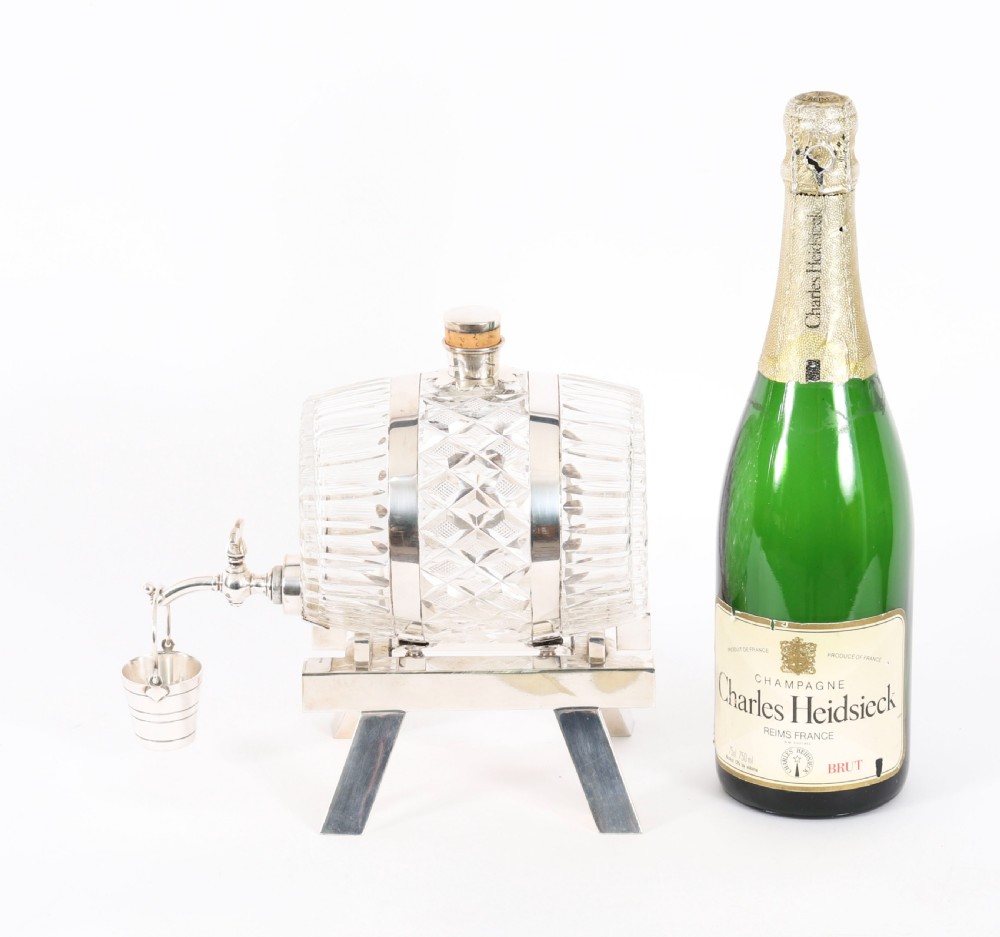 A nineteenth-century cut crystal barrel decanter with silver-plated hoops, tap, and miniature bucket accessory resting on a four-legged silver stand. View XII