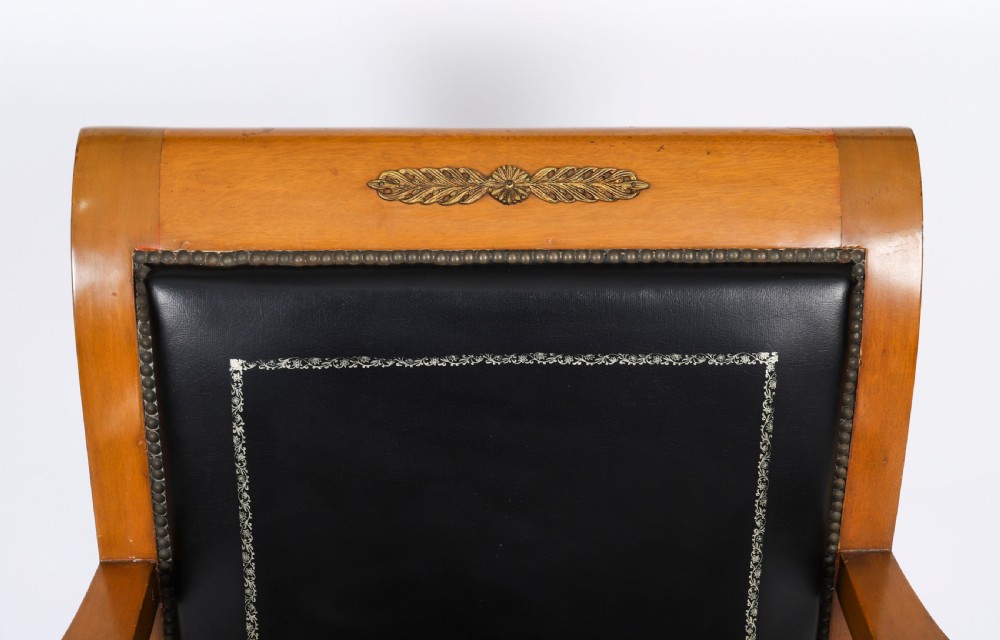 A nineteenth-century French Empire desk chair with black leather upholstery, mahogany frame, and gilt-bronze caryatid mounts. View III