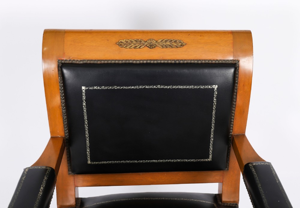 A nineteenth-century French Empire desk chair with black leather upholstery, mahogany frame, and gilt-bronze caryatid mounts. View IV