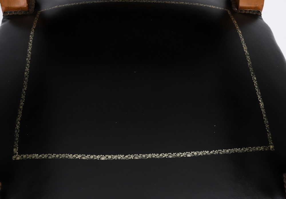 A nineteenth-century French Empire desk chair with black leather upholstery, mahogany frame, and gilt-bronze caryatid mounts. View VII