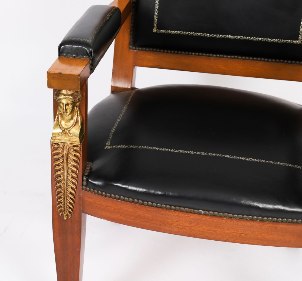 A nineteenth-century French Empire desk chair with black leather upholstery, mahogany frame, and gilt-bronze caryatid mounts. View VIII