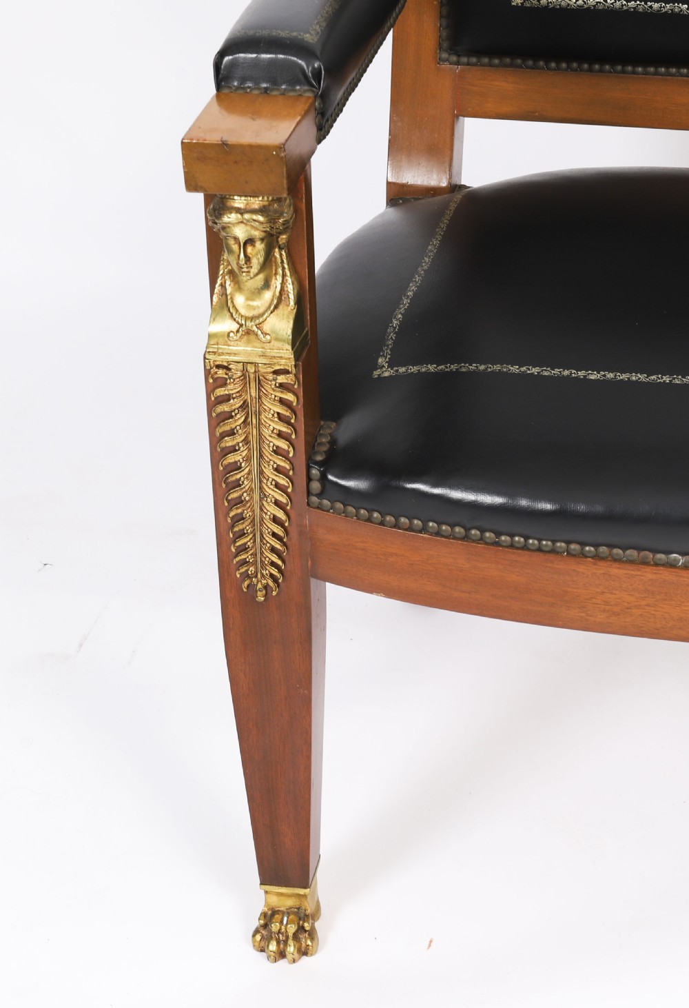 A nineteenth-century French Empire desk chair with black leather upholstery, mahogany frame, and gilt-bronze caryatid mounts. View X