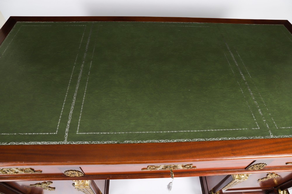 A French Empire style mahogany pedestal desk featuring a green leather top insert, decorative gilt-bronze mounts, and caryatid corner supports. View III