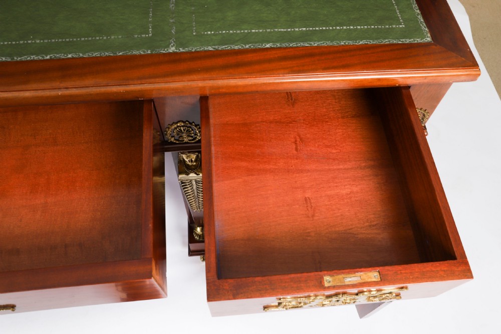 A French Empire style mahogany pedestal desk featuring a green leather top insert, decorative gilt-bronze mounts, and caryatid corner supports. View VII