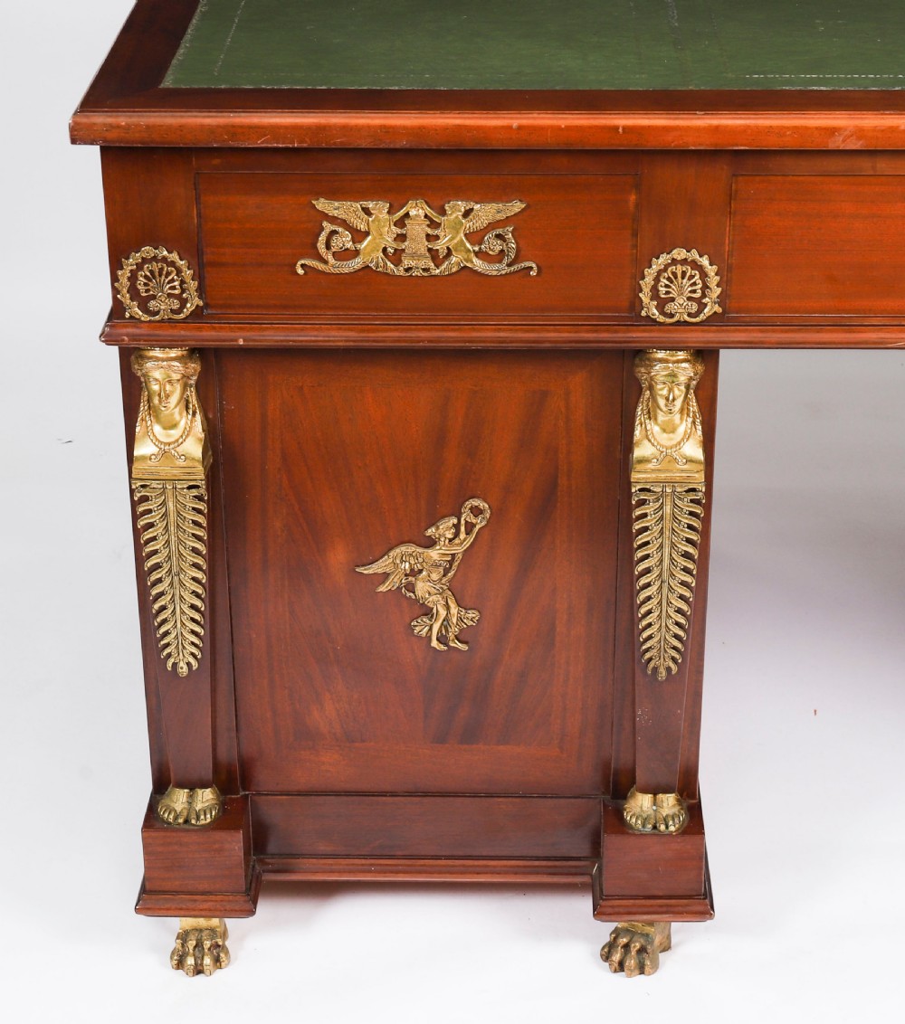 A French Empire style mahogany pedestal desk featuring a green leather top insert, decorative gilt-bronze mounts, and caryatid corner supports. View VIII