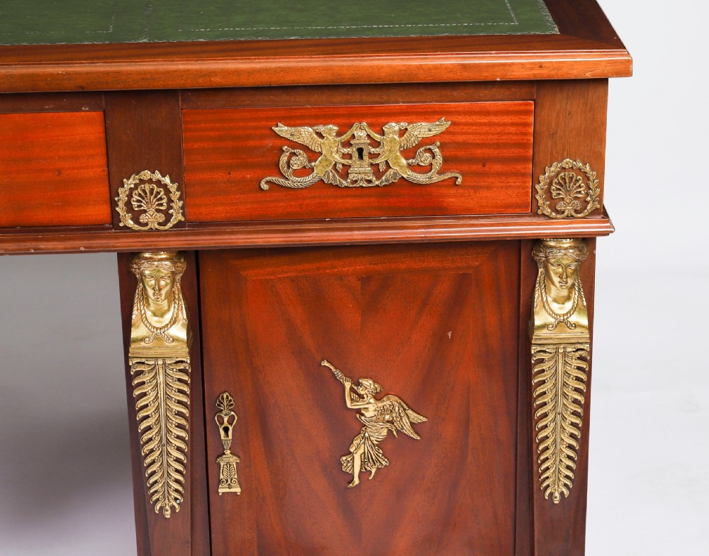 A French Empire style mahogany pedestal desk featuring a green leather top insert, decorative gilt-bronze mounts, and caryatid corner supports. View XI