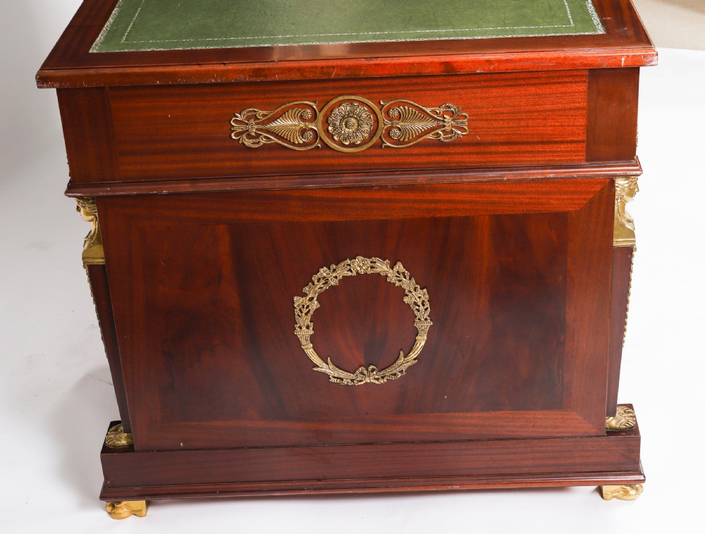 A French Empire style mahogany pedestal desk featuring a green leather top insert, decorative gilt-bronze mounts, and caryatid corner supports. View XVI