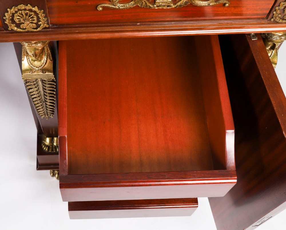 A French Empire style mahogany pedestal desk featuring a green leather top insert, decorative gilt-bronze mounts, and caryatid corner supports. View XVIII