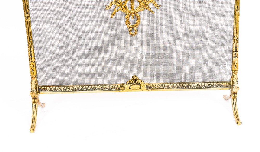 A French Empire Revival gilt bronze fire screen featuring a woven mesh panel, laurel wreath top handle, and central flaming torch motif on splayed feet. View VII