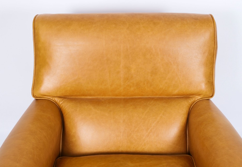 An Art Deco leather armchair upholstered in caramel tan hide with studded trim and square tapered wooden legs. View III