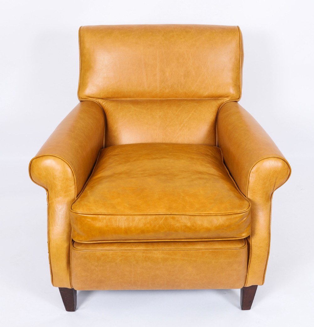 An Art Deco leather armchair upholstered in caramel tan hide with studded trim and square tapered wooden legs. View VII