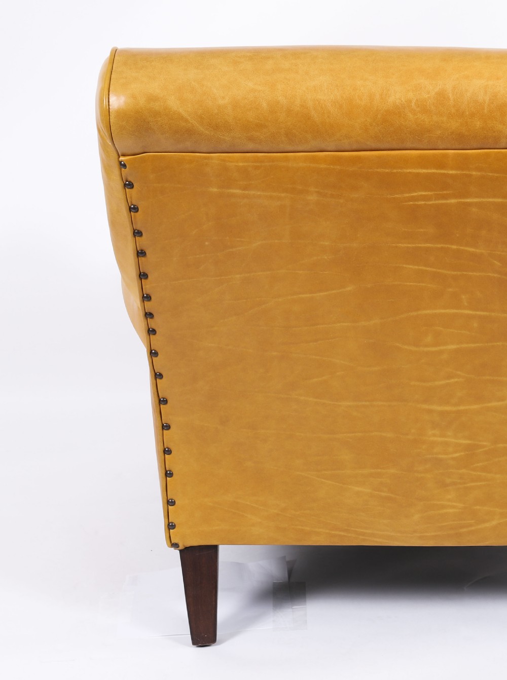 An Art Deco leather armchair upholstered in caramel tan hide with studded trim and square tapered wooden legs. View VIII