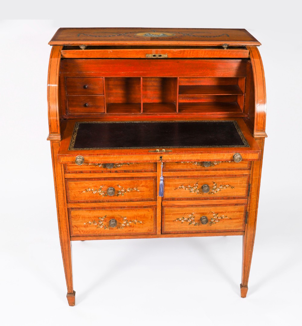 A late Victorian Sheraton Revival satinwood cylinder bureau featuring hand-painted floral swags, a central figural scene, and multiple small drawers above tapered legs. View III