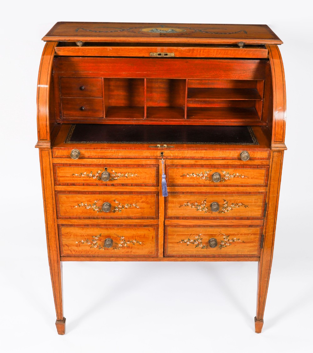 A late Victorian Sheraton Revival satinwood cylinder bureau featuring hand-painted floral swags, a central figural scene, and multiple small drawers above tapered legs. View VII