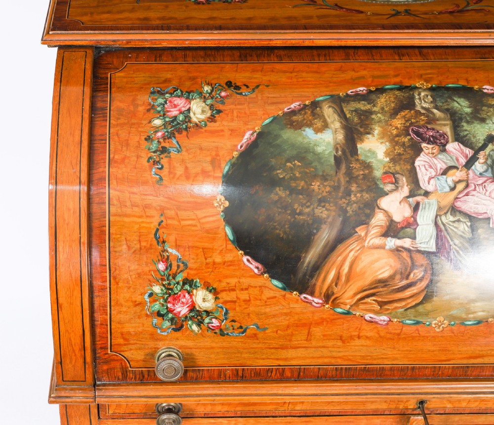 A late Victorian Sheraton Revival satinwood cylinder bureau featuring hand-painted floral swags, a central figural scene, and multiple small drawers above tapered legs. View VIII
