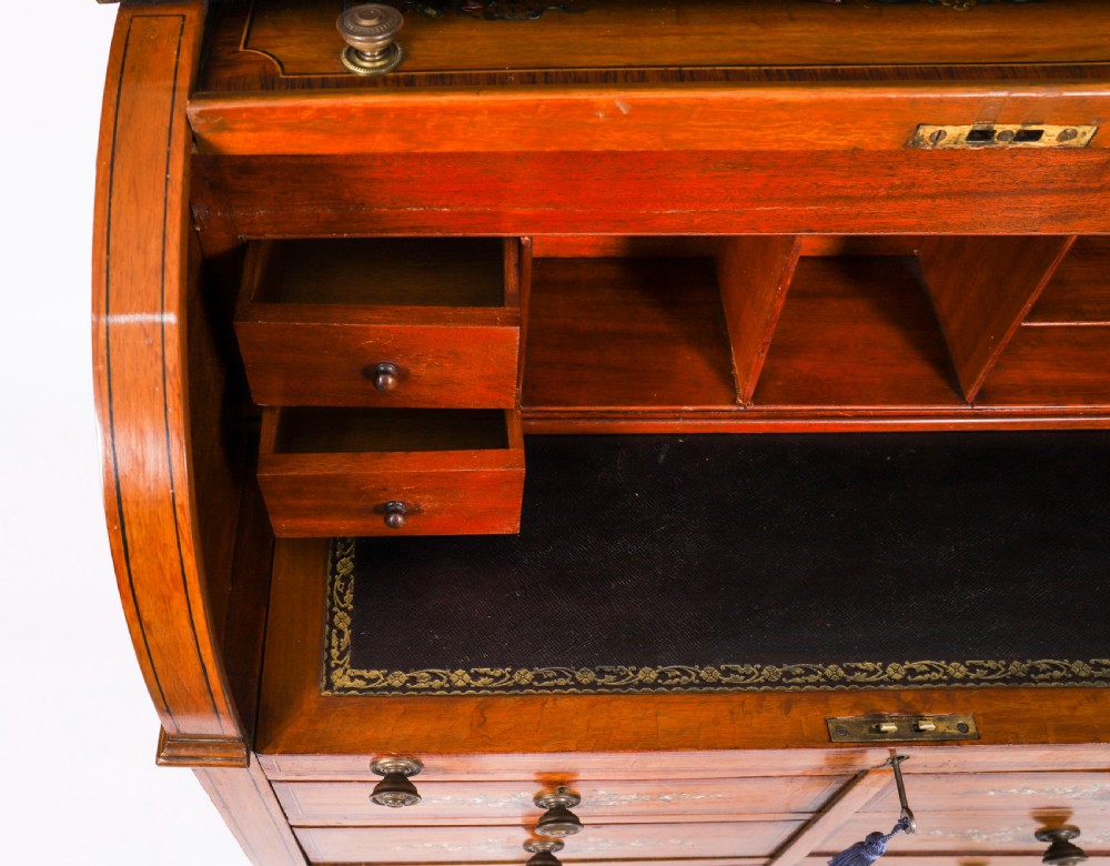 A late Victorian Sheraton Revival satinwood cylinder bureau featuring hand-painted floral swags, a central figural scene, and multiple small drawers above tapered legs. View XV